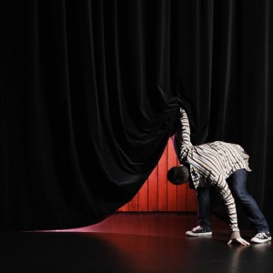 Actor peeking under curtain